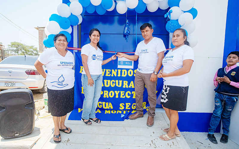 A group of individuals standing in front of a bright blue door, representing community and shared experiences.