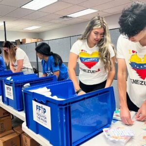 two FFTPvolunteers with Ven ezuela t shirts pack kits to be sent to Venezuela after earthquake