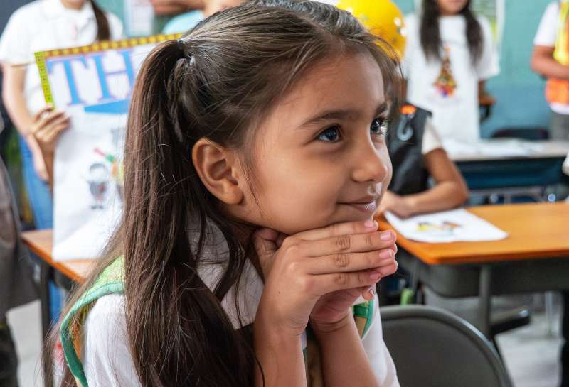 a young girl who lives in the Bosques de Santa Lucia sustainable community sitting at a desk